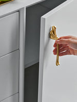 Hand pulling open drawer with gold thinker figure handle