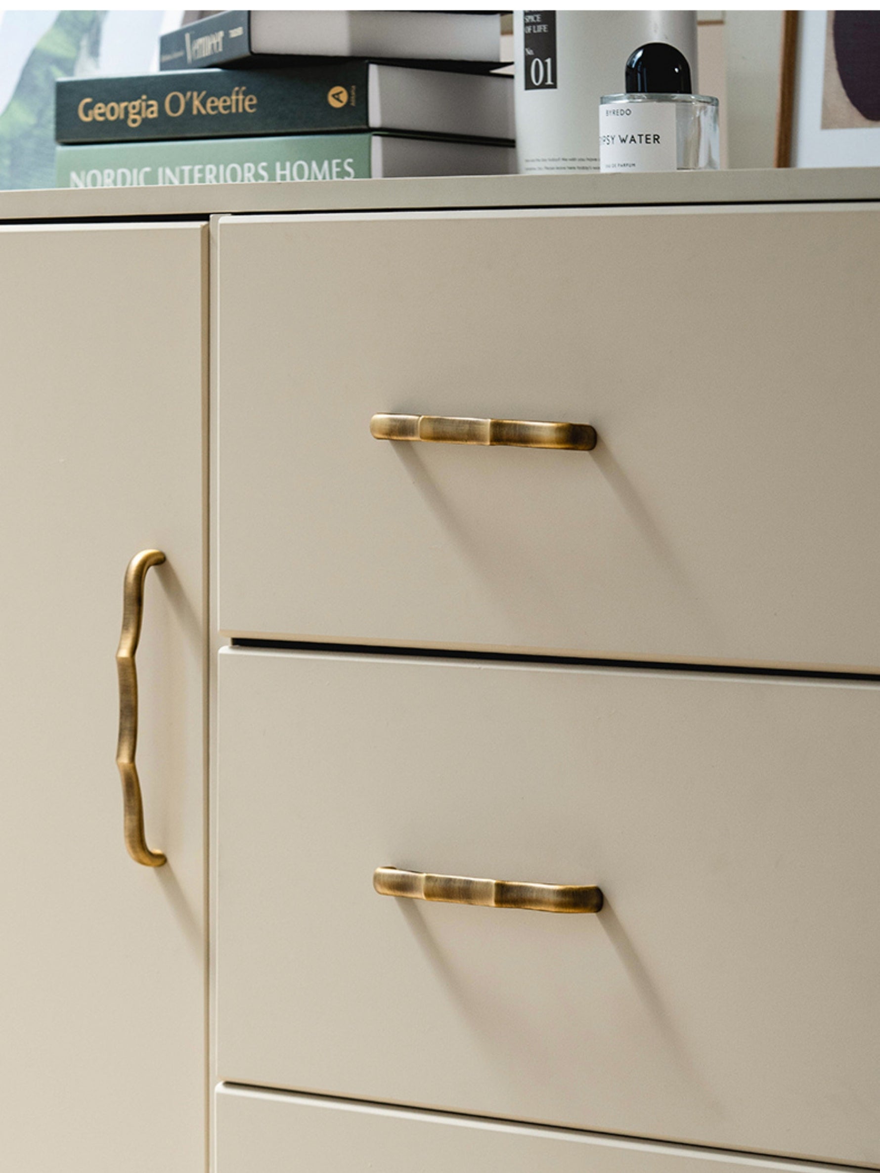 Antique brass bamboo pulls on beige chest of drawers — styled