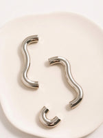 Nickel chrome wavy pulls and arch knobs from above showing curved silhouette