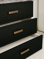Open black drawer chest showing solid brass Art Deco arch pulls on three drawer fronts