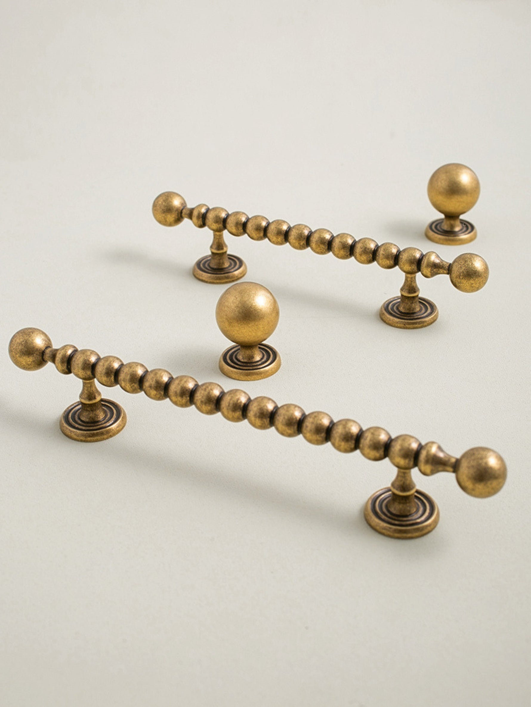 Set of antique brass cabinet handles on a beige background