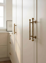 White cabinet with antique handles in a kitchen setting
