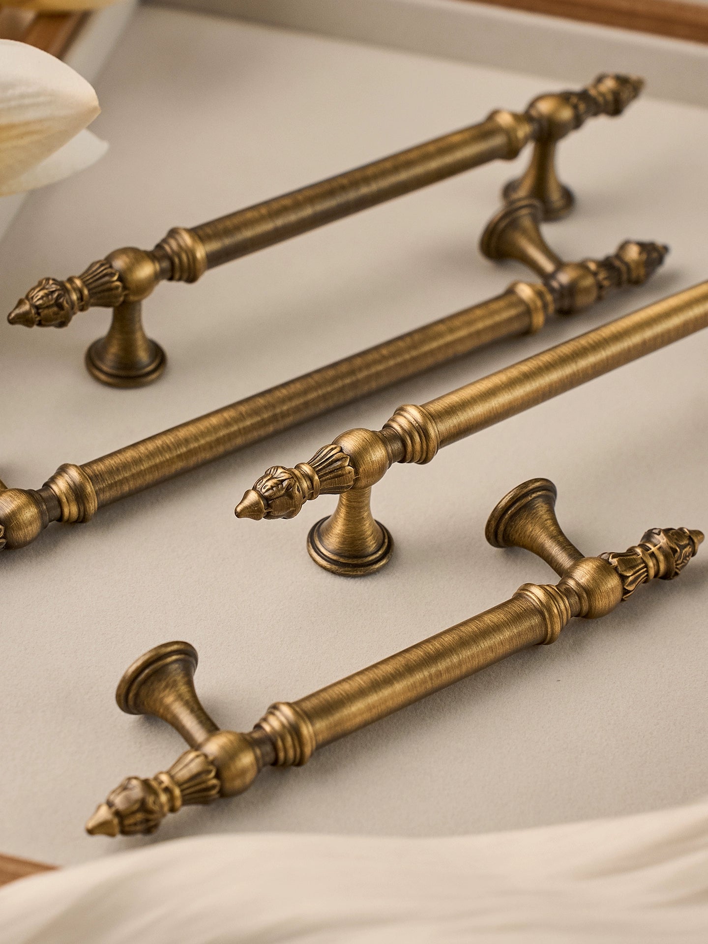 Set of ornate brushed brass cabinet handles on a light background