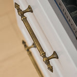 Decorative brushed brass handle on a white surface with 'KINFOLK' branding.