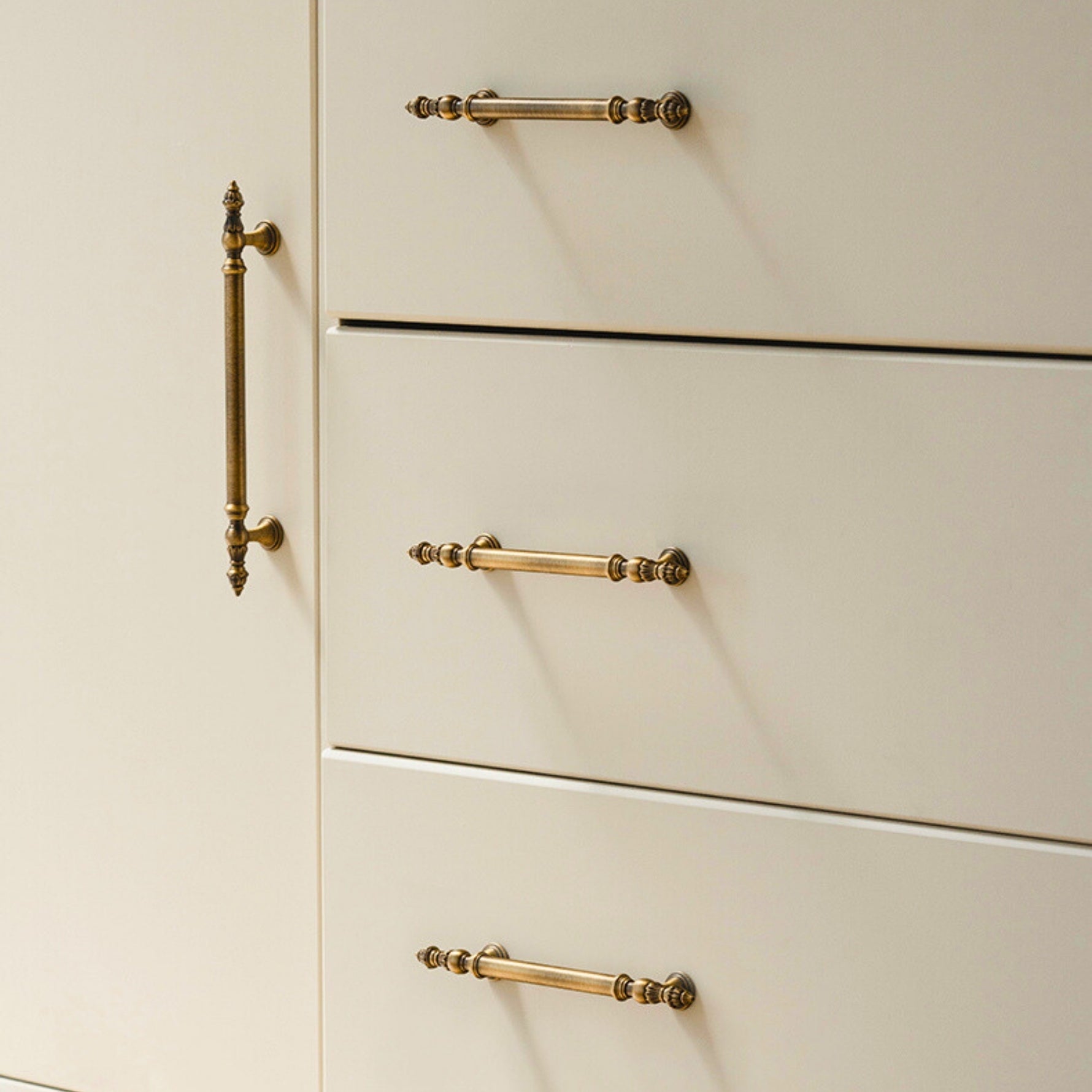 Close-up of beige cabinets with brushed brass handles on a neutral background