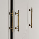 Close-up of white cabinet doors with brushed brass handles on a neutral background