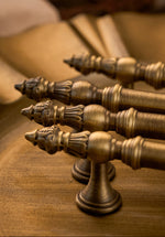 Set of ornate brushed brass door handles on a wooden surface